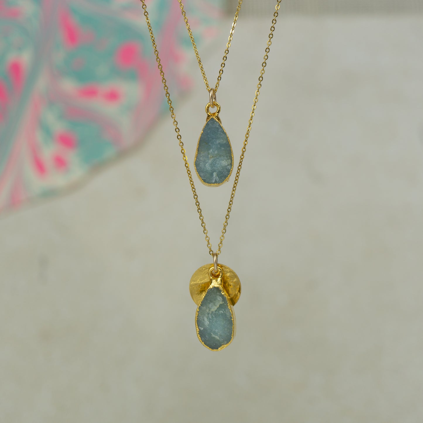 Raw blue Aquamarine teardrop pear shaped pendants finished in gold on a chains.
