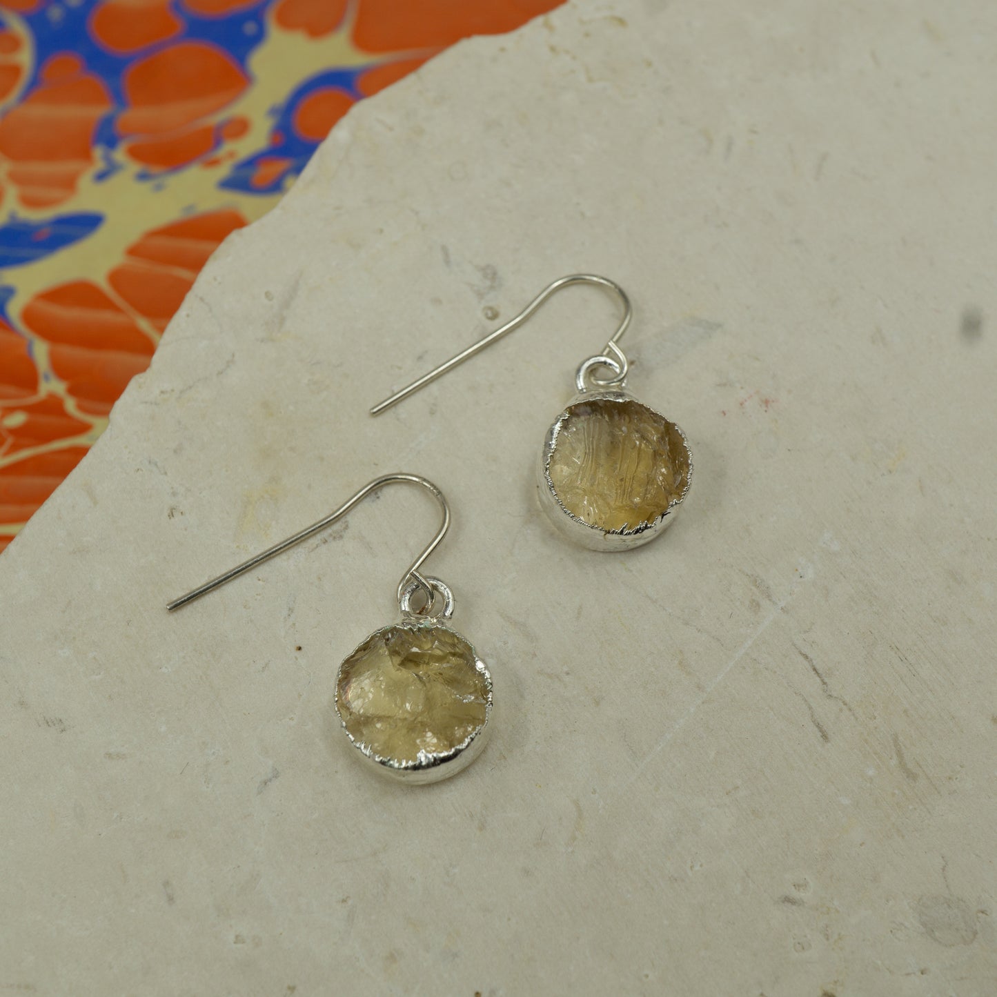 Round raw yellow citrine earrings on hooks finished in silver.