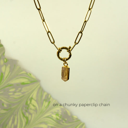 A gold paperclip chain necklace with a small rectangular faceted Imperial Topaz crystal pendant.