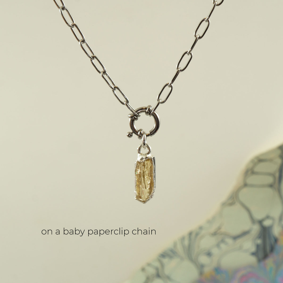 A baby paperclip silver chain necklace with a small rectangular faceted Imperial Topaz gemstone pendant.