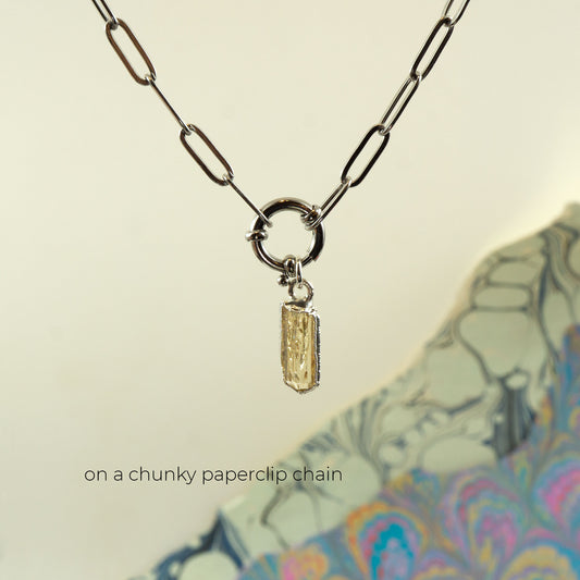 A silver paperclip chain necklace with a ring clasp and a small rectangular faceted Imperial Topaz crystal pendant.
