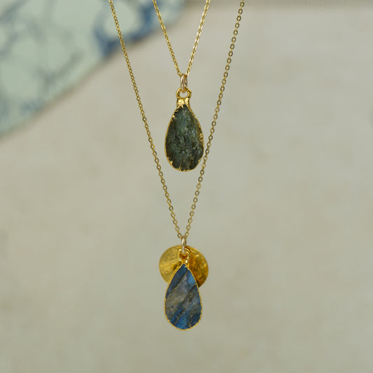 single teardrop raw labradorite pendants finished in gold on a chains.