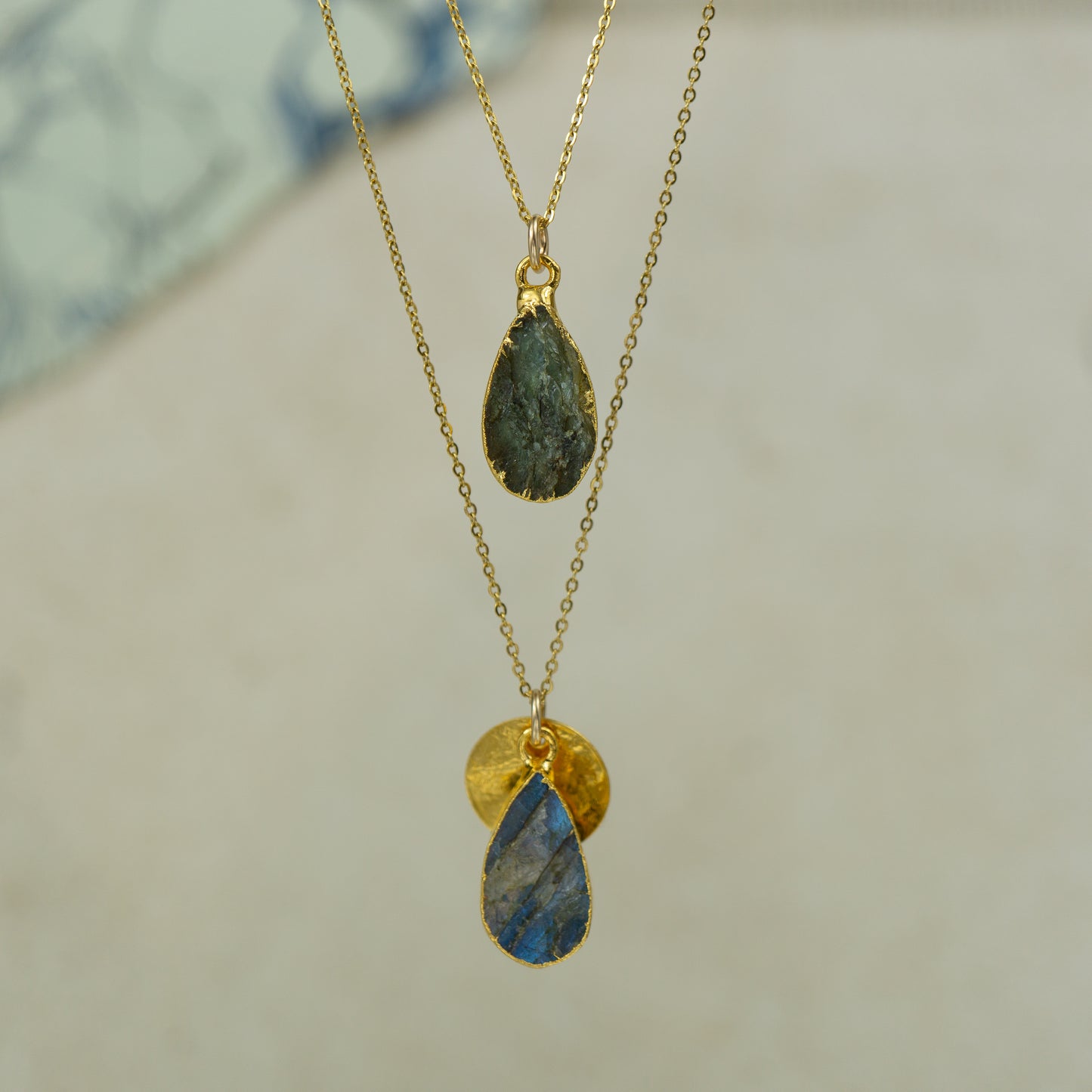 single teardrop raw labradorite pendants finished in gold on a chains. 