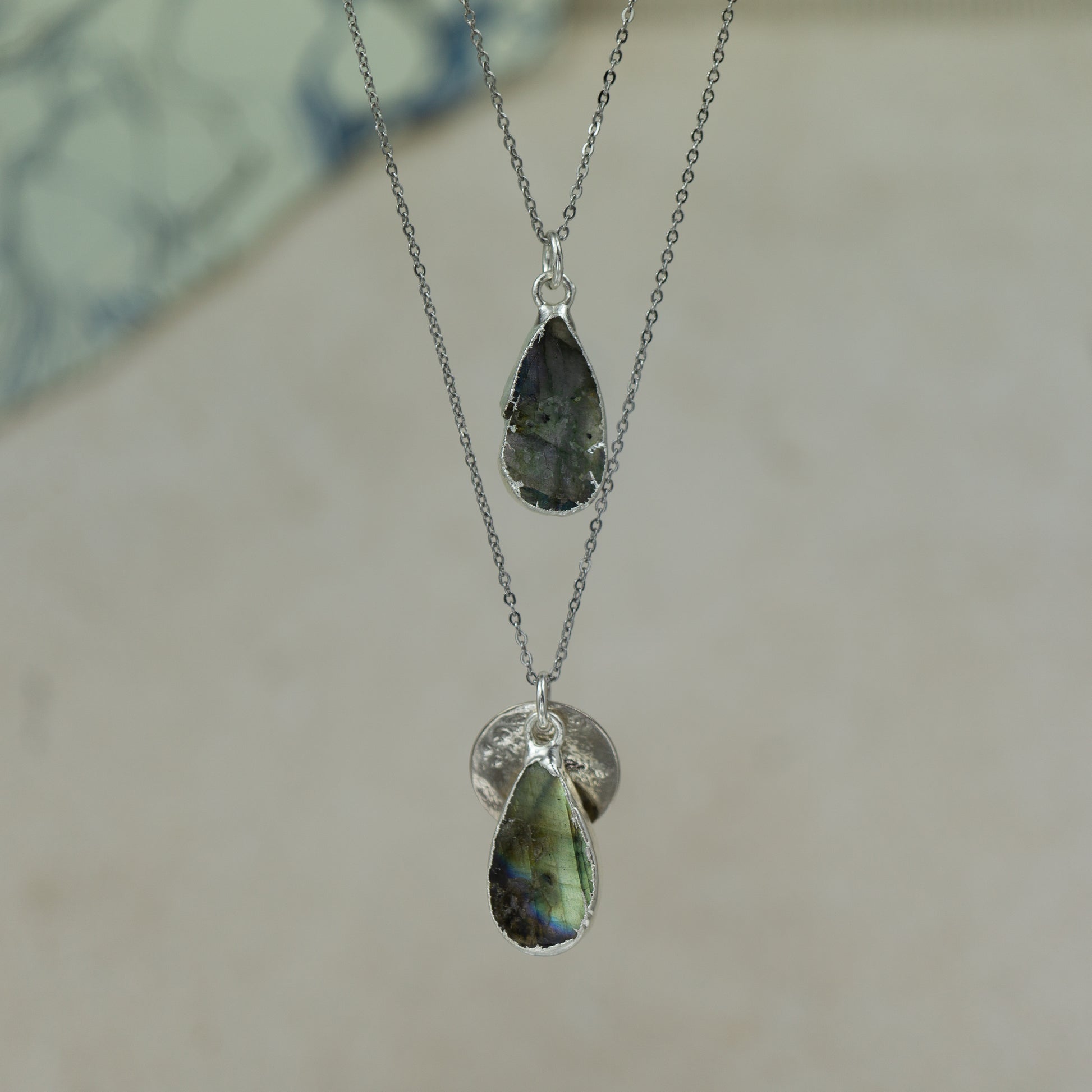 single teardrop raw labradorite pendants finished in gold on a chains.