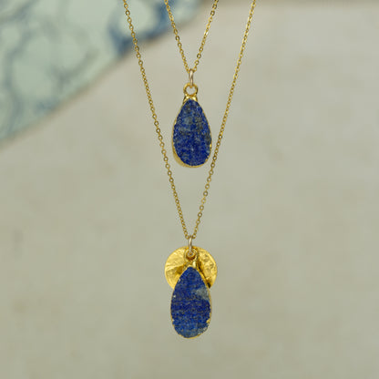 Raw blue Lapis Lazuli teardrop pear shaped pendants finished in gold on a chains.