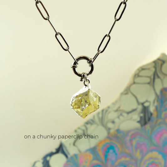 A necklace with a faceted pale yellow Lemon Quartz gemstone pendant on a chunky black paperclip chain