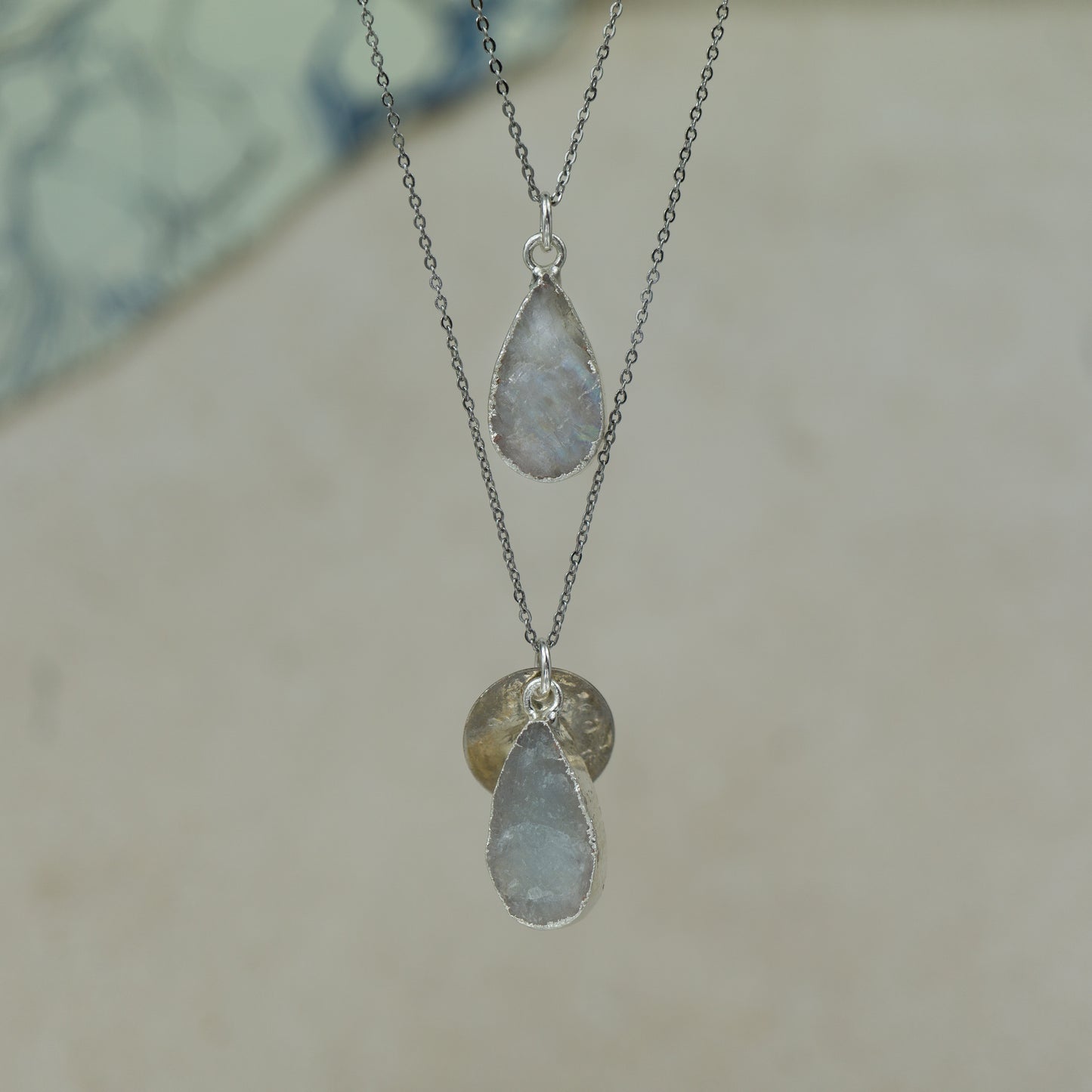 Raw white moonstone teardrop pear shaped pendants finished in silver on a chains.