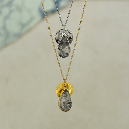 white and black Rutilated quartz teardrop pear shaped pendant with small back disk on a chain in gold and silver