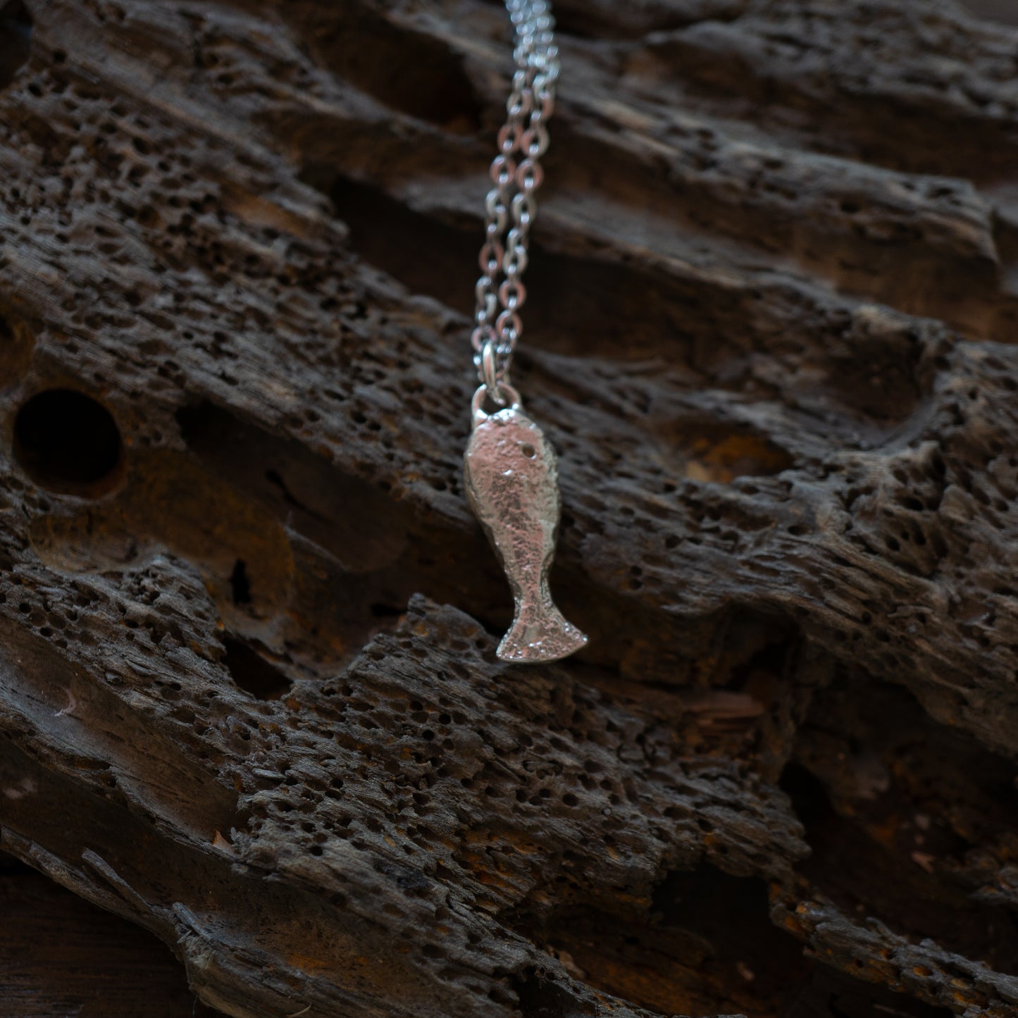 Silver textured fish charm on a chain
