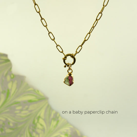 Gold paperclip chain necklace with a small charm featuring a pink and green Watermelon Tourmaline gemstone.