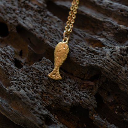 gold textured fish charm on a chain 