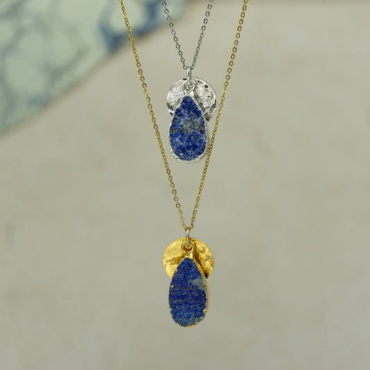 raw blue lapis lazuli teardrop pear shaped pendant with small back disk on a chain in gold and silver.