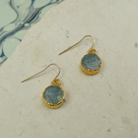 Round raw Blue aquamarine  earrings on hooks finished in gold.