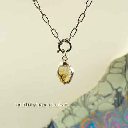 A silver baby paperclip chain necklace with a polished, irregular-shaped yellow citrine gemstone pendant