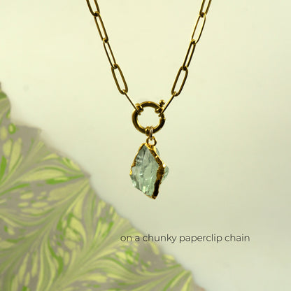 A gold paperclip chain necklace with a ring clasp and a raw, irregular Green Amethyst gemstone pendant,