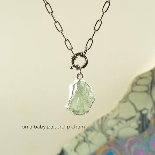 A silver paperclip chain necklace with a raw, irregular Green Amethyst gemstone pendant