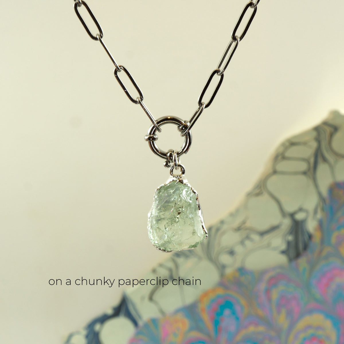 A necklace with a chunky silver paperclip chain and a raw, irregular Green Amethyst gemstone pendant