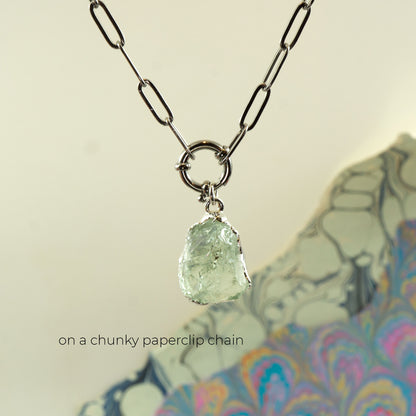 A necklace with a chunky silver paperclip chain and a raw, irregular Green Amethyst gemstone pendant