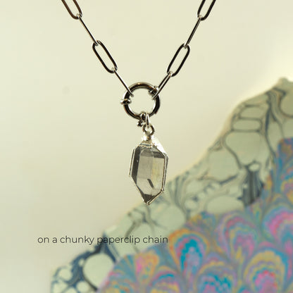 A silver paperclip chain necklace with a clear faceted Herkimer diamond gem stone pendant,