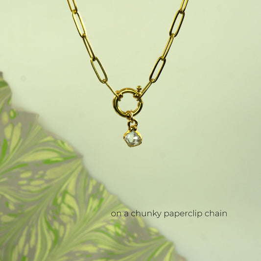 Gold paperclip chain necklace with a small clear faceted herkimer diamond gemstone pendant