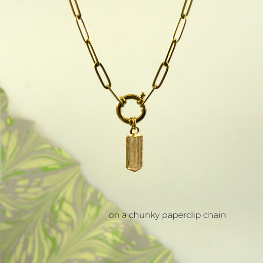 A gold-toned paperclip chain necklace with a small rectangular Imperial Topaz pendant.