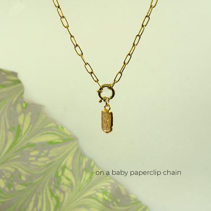 A gold paperclip chain necklace with a small rectangular faceted Imperial Topaz gemstone pendant.