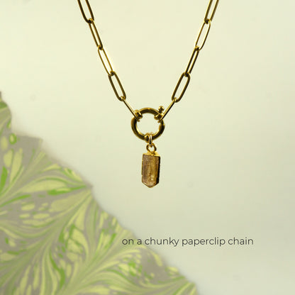 A gold paperclip chain necklace with a small rectangular faceted Imperial Topaz crystal pendant.