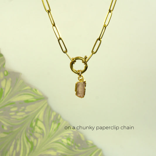 A gold paperclip chain necklace with a small druzy Imperial Topaz stone pendant.