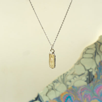 A delicate silver chain necklace with a small rectangular faceted Imperial Topaz crystal pendant.