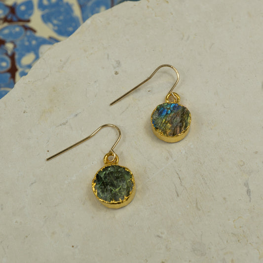 Round raw Labradorite earrings on hooks finished in gold.