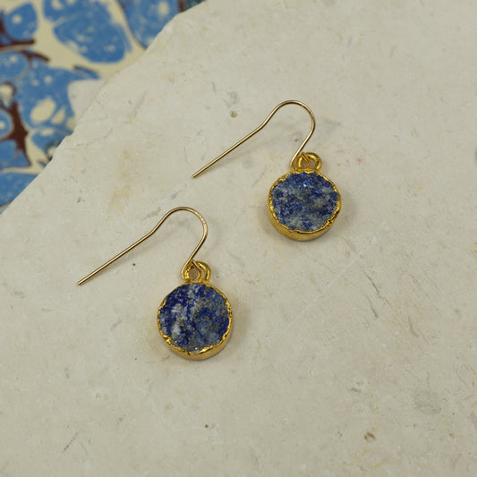 Round raw Blue Lapis Lazuli earrings on hooks finished in gold.
