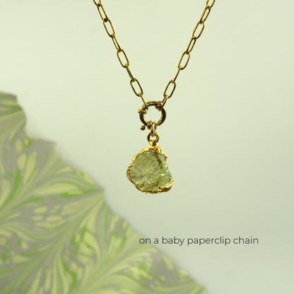 A gold paperclip chain necklace with a raw, irregular-cut light Lemon Quartz gemstone pendant