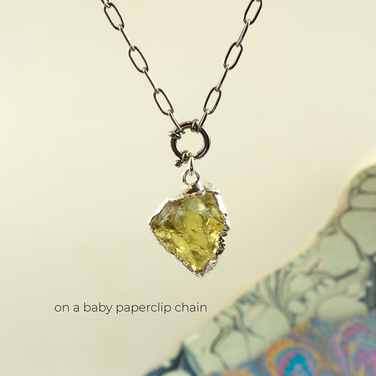 A silver paperclip chain necklace with a raw, irregular-cut Lemon Quartz gemstone pendant