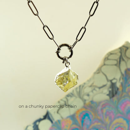 A necklace with a faceted pale yellow Lemon Quartz gemstone pendant on a chunky black paperclip chain