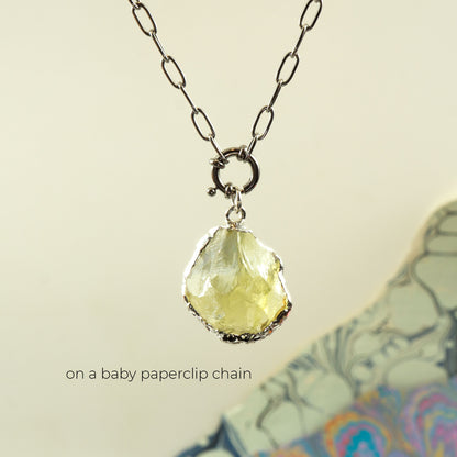 A silver paperclip chain necklace with a raw, faceted pale Lemon Quartz gemstone pendant