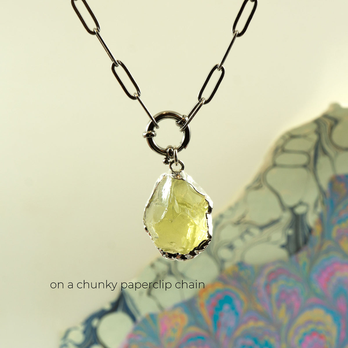 A necklace with a chunky paperclip chain and a faceted pale yellow Lemon Quartz gemstone pendant