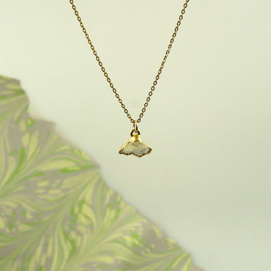 A gold chain necklace with a small pendant made from a natural, polished white Rainbow Moonstone.