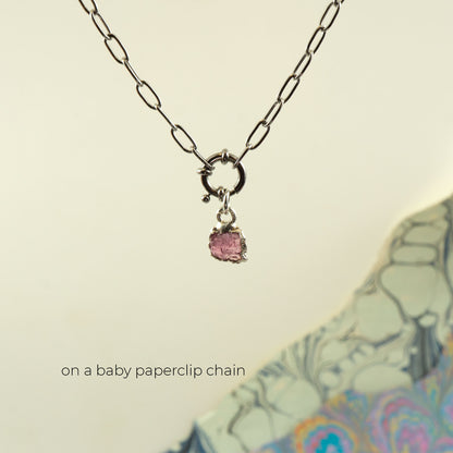 A silver paperclip chain necklace with a small silver ring clasp holding a Pink Tourmaline faceted gemstone pendant