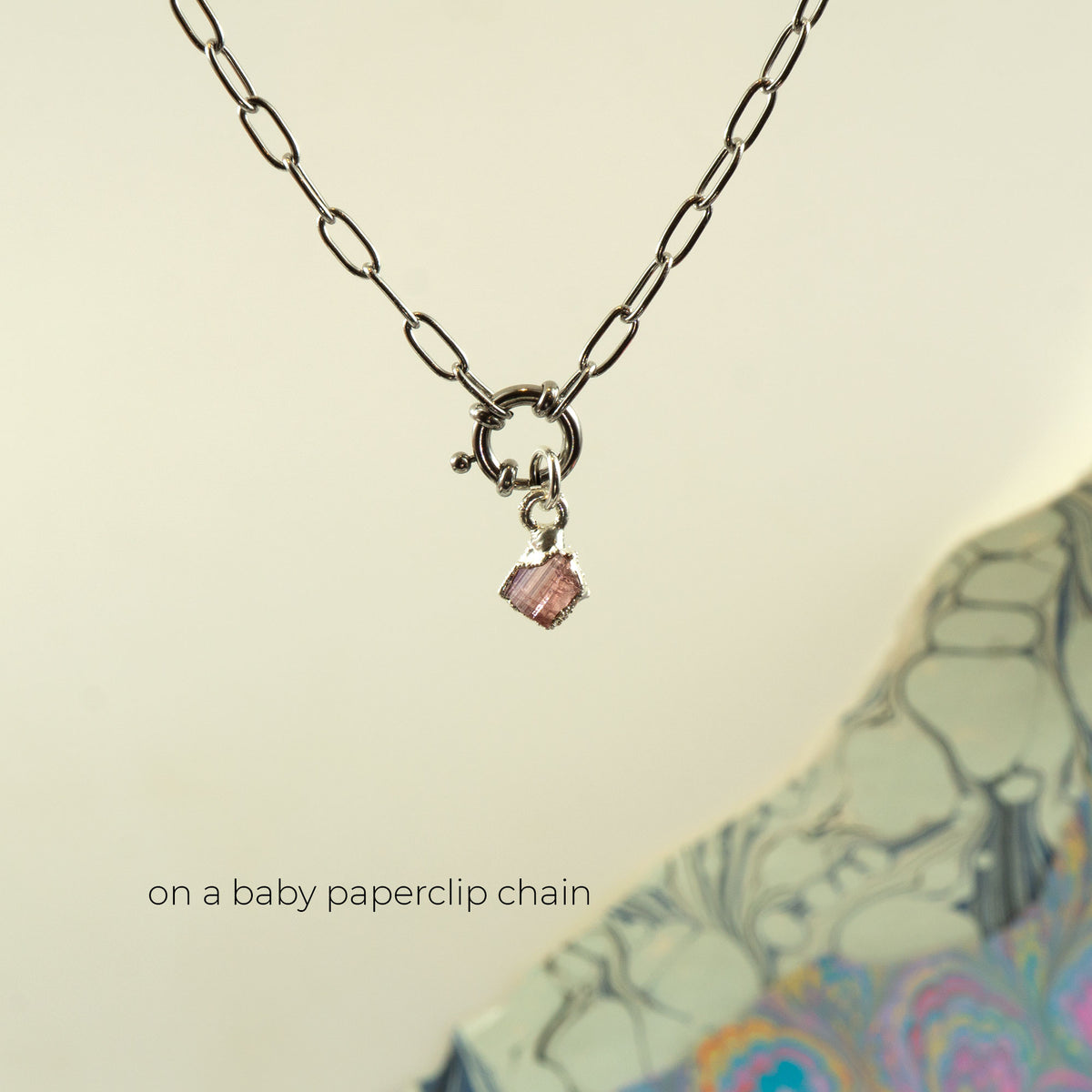 A silver paperclip chain necklace with a small Pink Tourmaline gemstone charm
