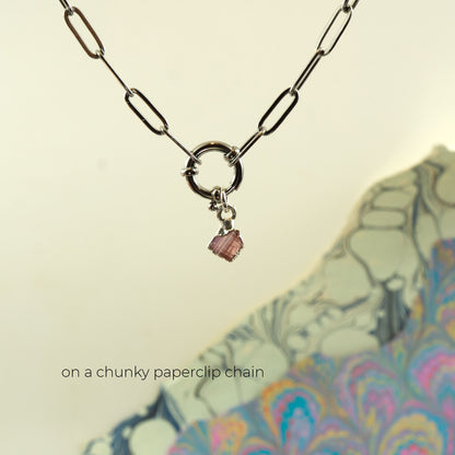 A silver-toned paperclip chain necklace with a circular ring clasp and a small Pink Tourmaline faceted gemstone charm