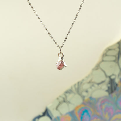 A delicate silver chain necklace with a small pendant featuring a Pink Tourmaline faceted gemstone.
