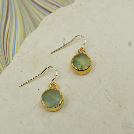 Round raw green Prehnite earrings on hooks finished in gold.