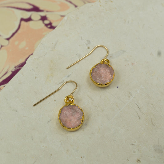 Round raw pink rose quartz earrings on hooks finished in gold.