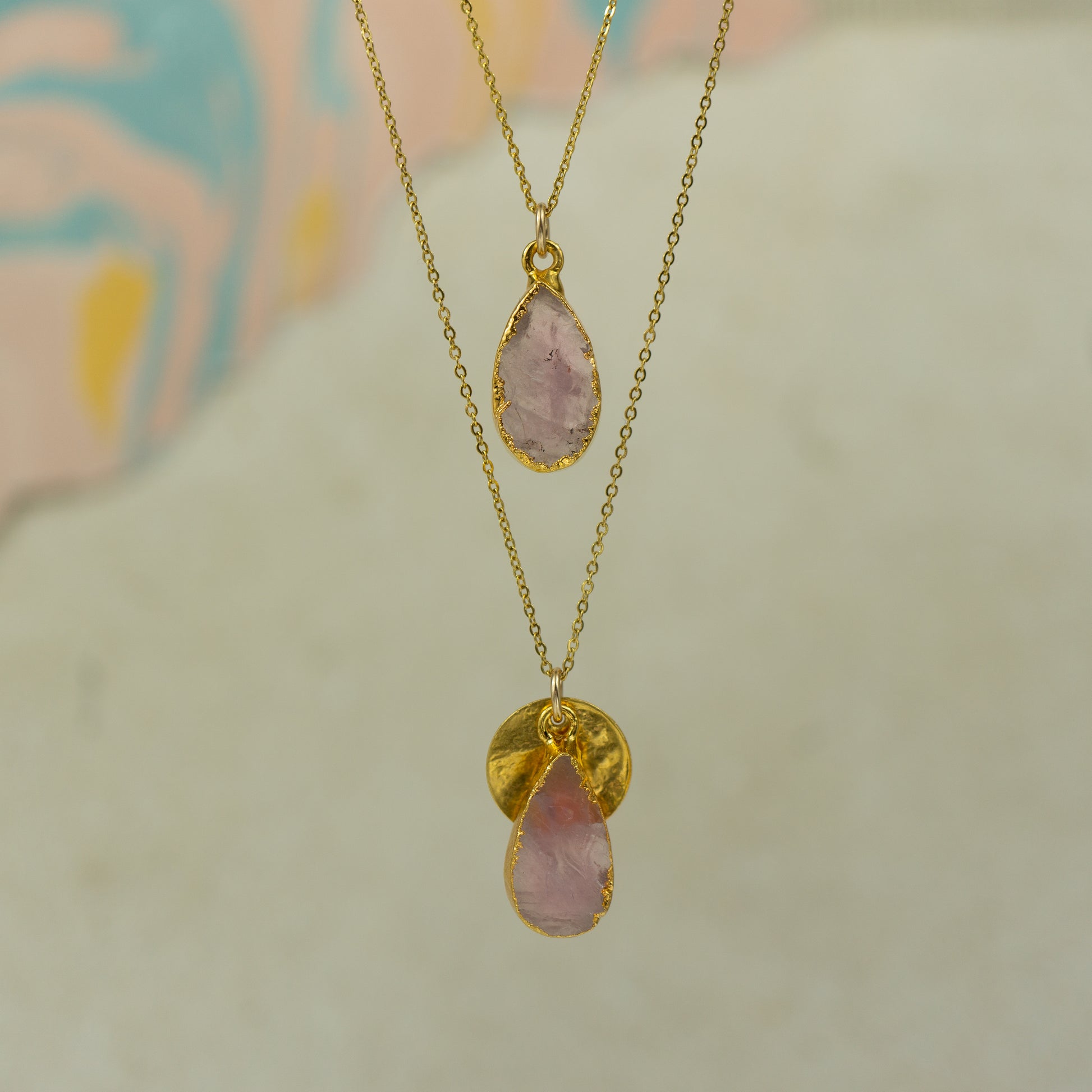 single teardrop raw pink rose quartz pendants finished in gold on a chains.