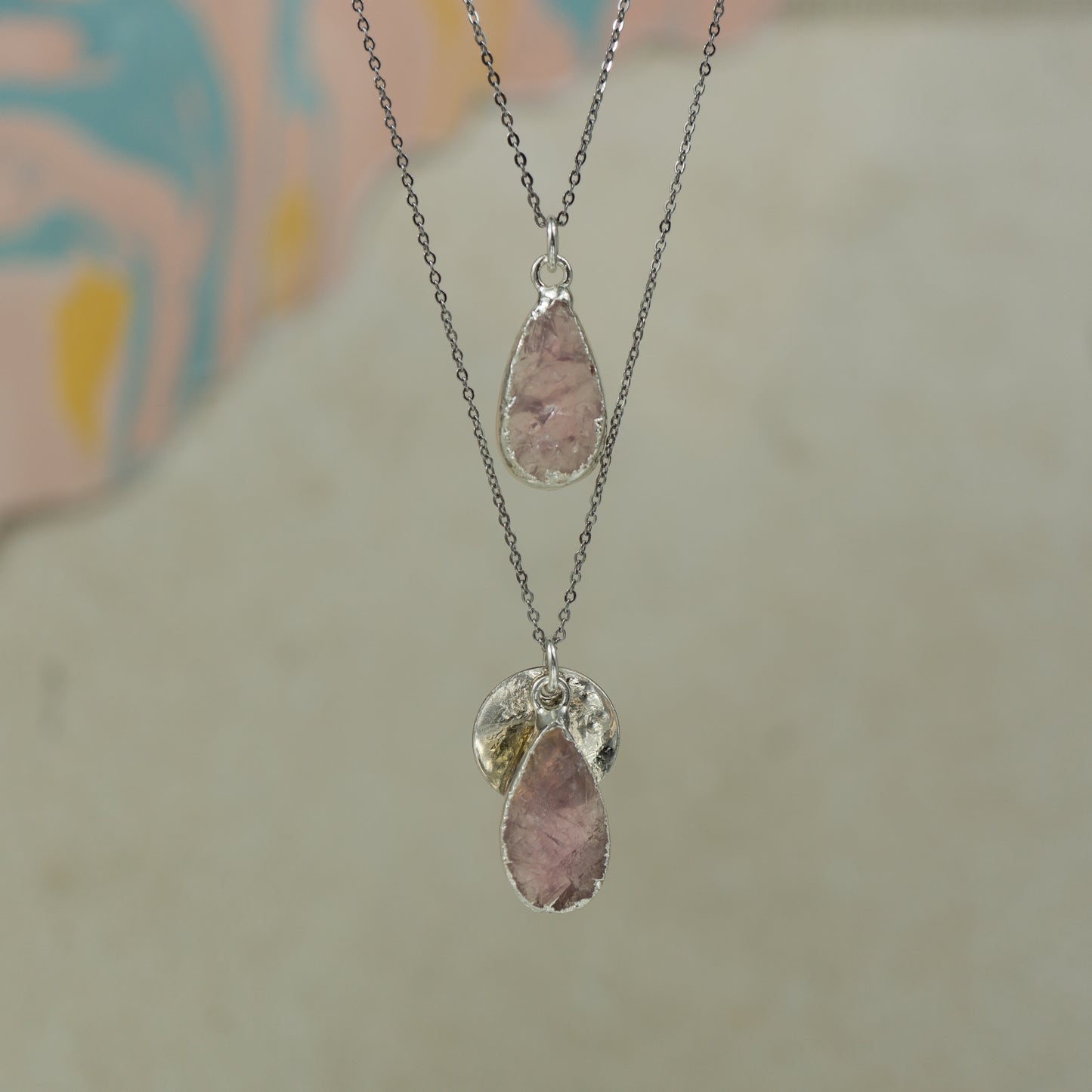 single teardrop pink rose quartz pendants finished in silver on a chains.