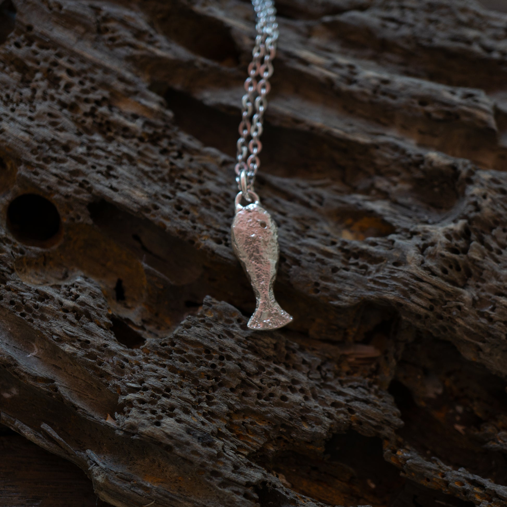 Silver textured fish charm on a chain