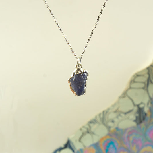 beautiful blue-purple raw tanzanite gemstone pendant embezzled in solid silver, on a delicate plain silver chain.